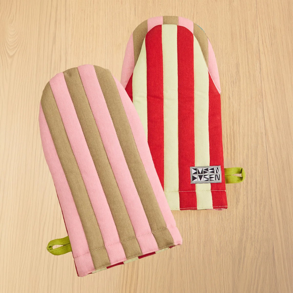 Two striped Dusen Dusen oven mitts in pink, red, cream, and brown