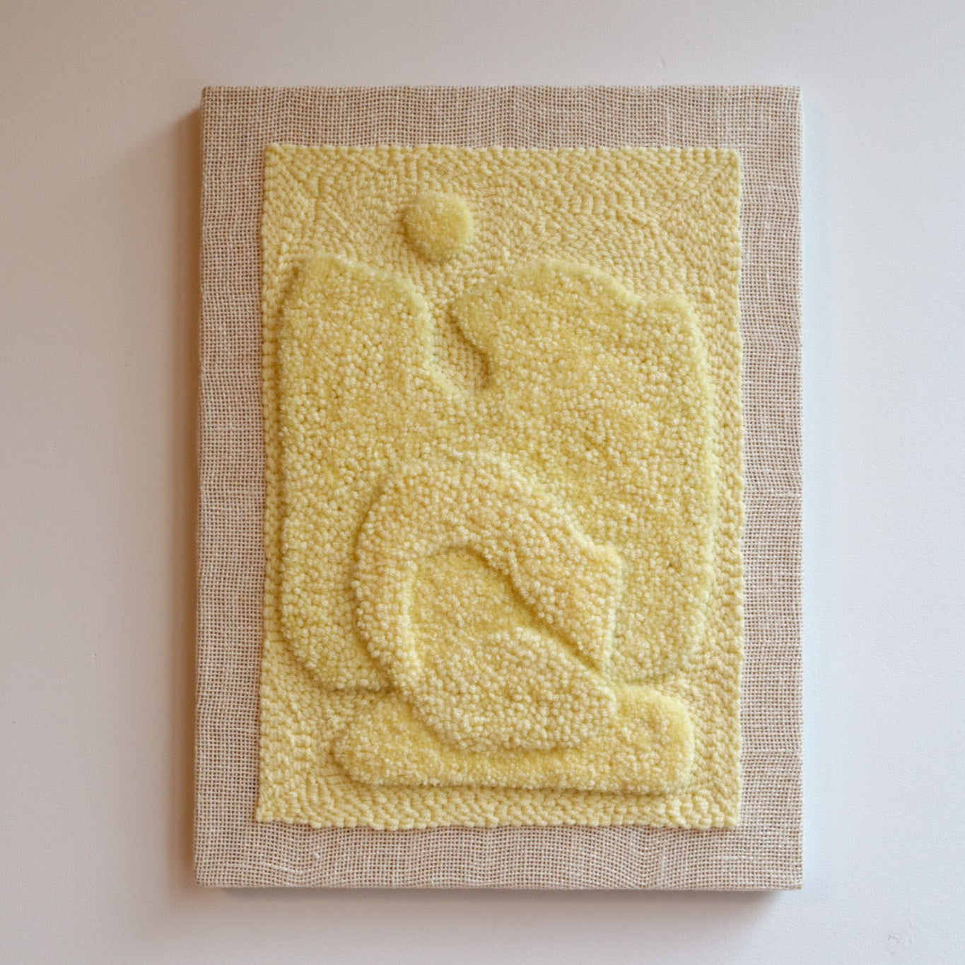 Textured yellow wall art on a beige frame against a light gray background
